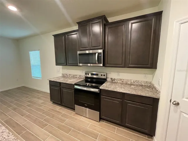 a kitchen with granite countertop stainless steel appliances and wooden cabinets