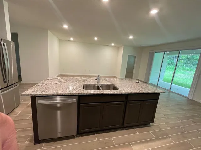 a kitchen with stainless steel appliances granite countertop a sink and a refrigerator