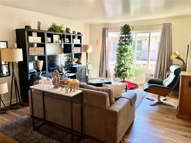 a living room with furniture large window and wooden floor