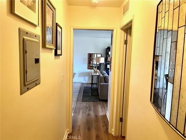 a view of a hallway with wooden floor and livingroom