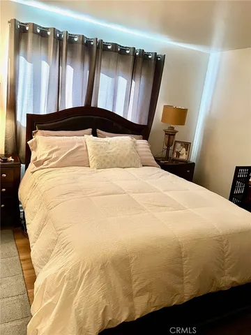 a bedroom with a bed and wooden floor