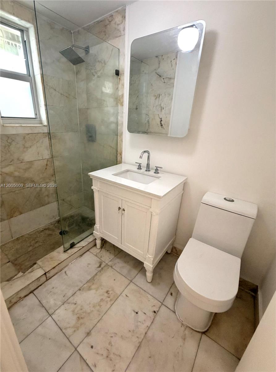801 8th Street, Unit 104 Miami Beach, FL 33139 - Photo 7 of 8 a bathroom with a toilet sink and mirror