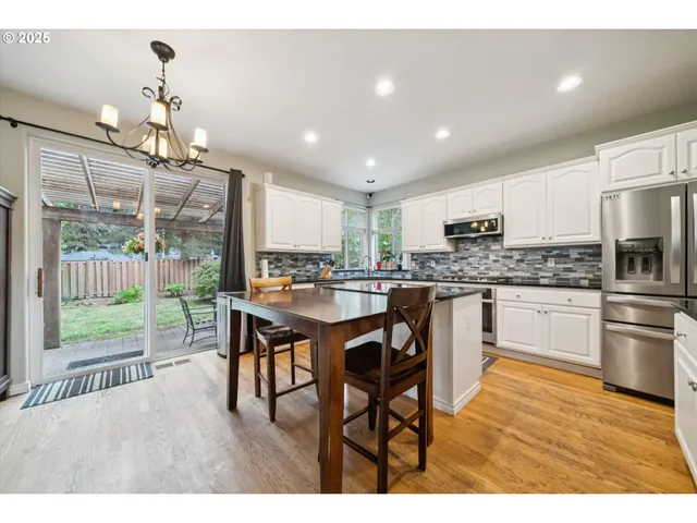 a kitchen with kitchen island granite countertop wooden floors and white appliances