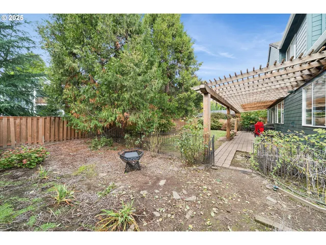 a view of a backyard with potted plants and wooden fence