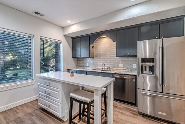 a kitchen with a refrigerator a stove and a sink