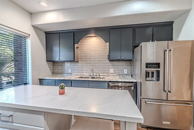 a kitchen with refrigerator and cabinets