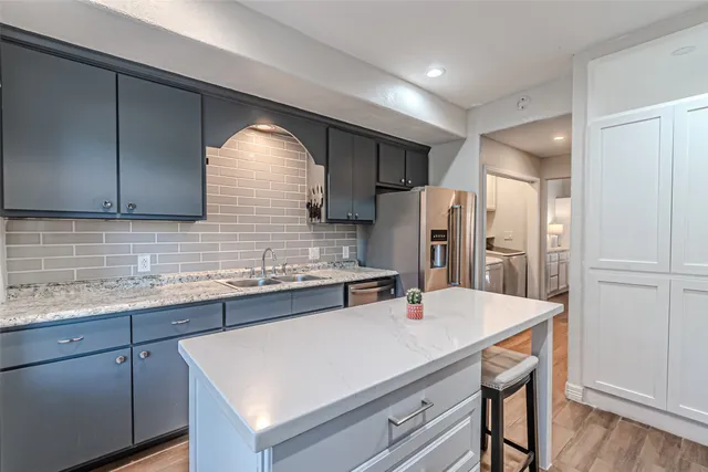 a kitchen with stainless steel appliances a sink and refrigerator
