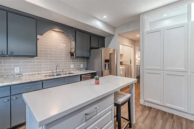 a kitchen with stainless steel appliances a refrigerator and sink
