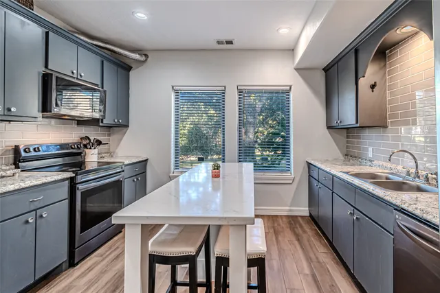 a kitchen with a table chairs microwave and cabinets