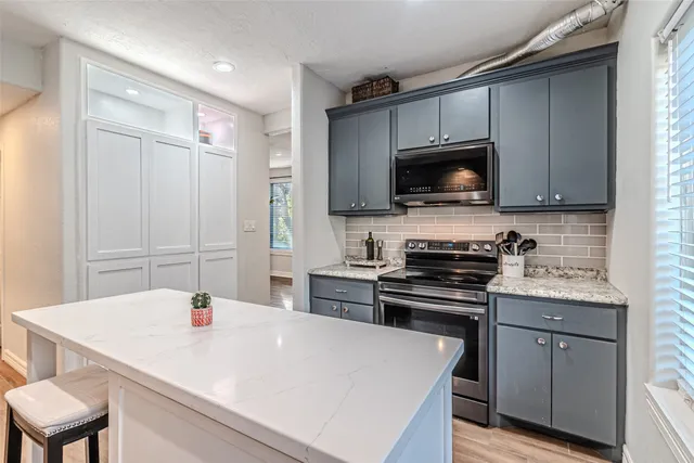 a kitchen with a sink a stove and cabinets