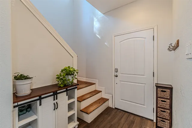 a view of a hallway with wooden floor and a potted plant
