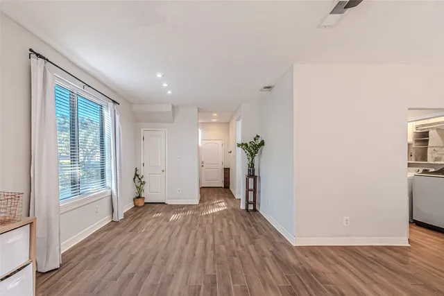 a view of a big room with wooden floor and windows