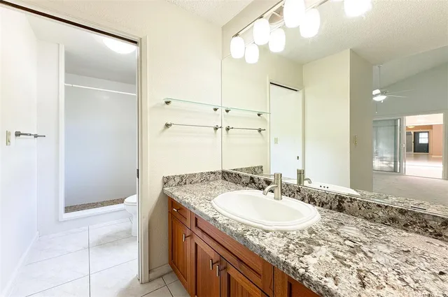 a bathroom with a granite countertop sink and a mirror