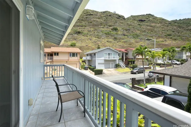 a view of a balcony with two chairs and a potted plant