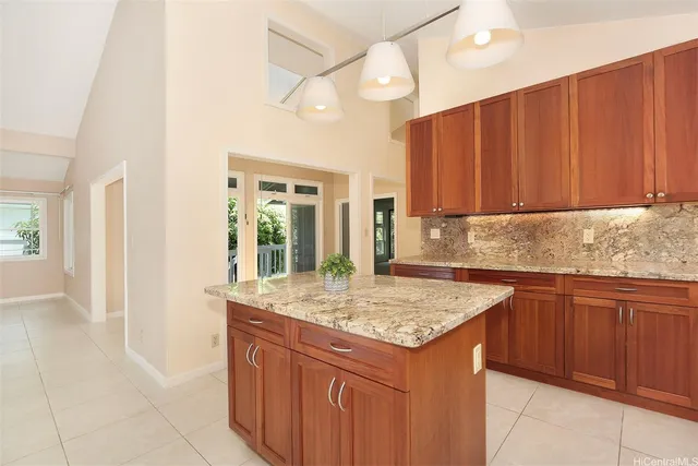 a kitchen with kitchen island granite countertop wooden cabinets a sink and dishwasher