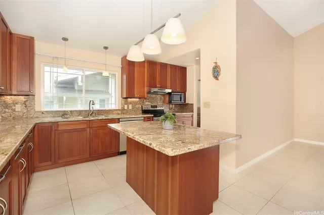 a kitchen with granite countertop a sink window and cabinets