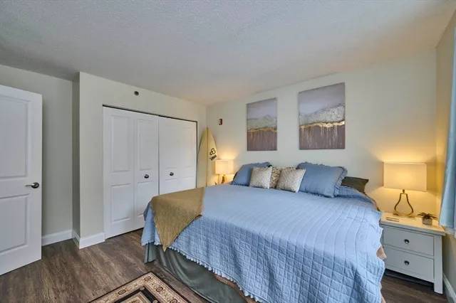 a bedroom with a bed and a large window with wooden floor