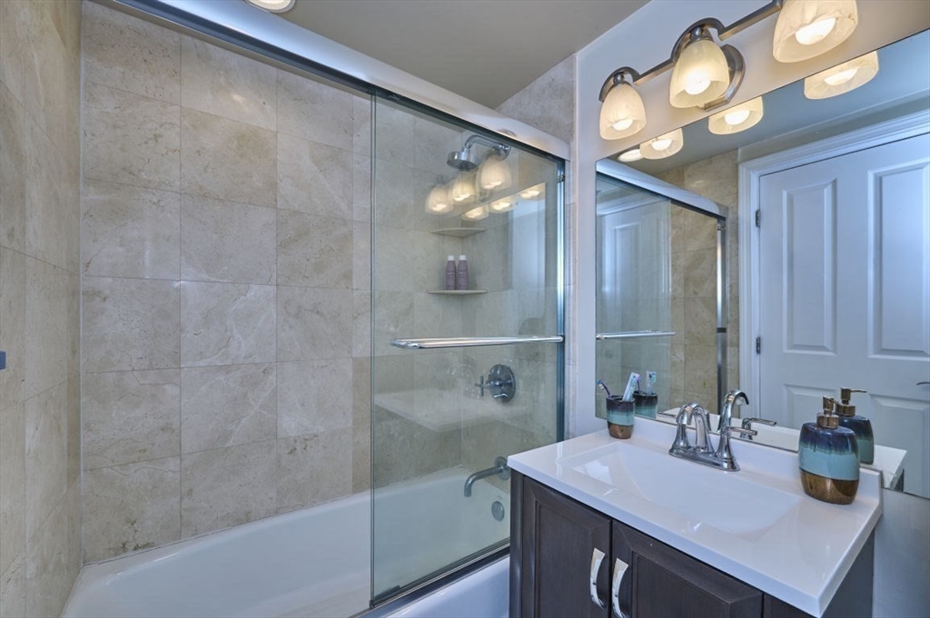 10 Museum Way, Unit 525 Cambridge, MA 02141 - Photo 16 of 22 a bathroom with a sink a mirror and a shower