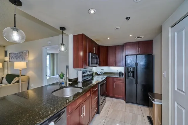a kitchen with granite countertop a sink and cabinets