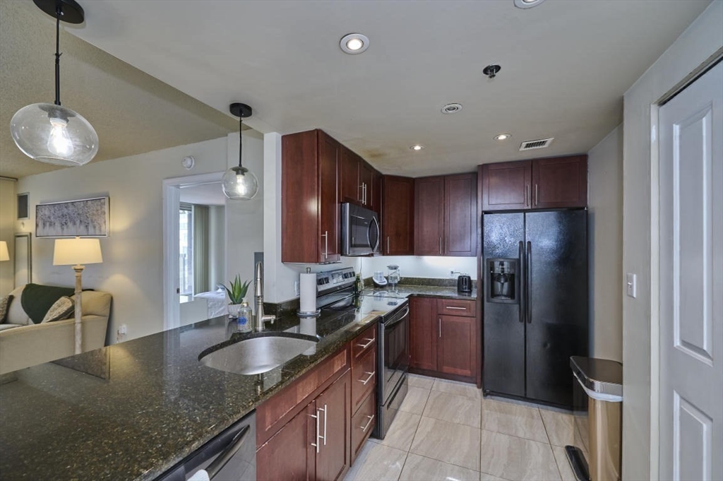 10 Museum Way, Unit 525 Cambridge, MA 02141 - Photo 6 of 22 a kitchen with granite countertop a sink stove and refrigerator