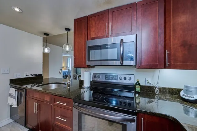 a kitchen with stainless steel appliances granite countertop a sink refrigerator and cabinets