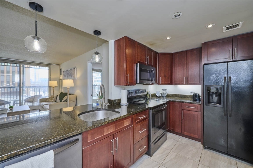 10 Museum Way, Unit 525 Cambridge, MA 02141 - Photo 8 of 22 a kitchen with stainless steel appliances granite countertop a sink refrigerator and cabinets