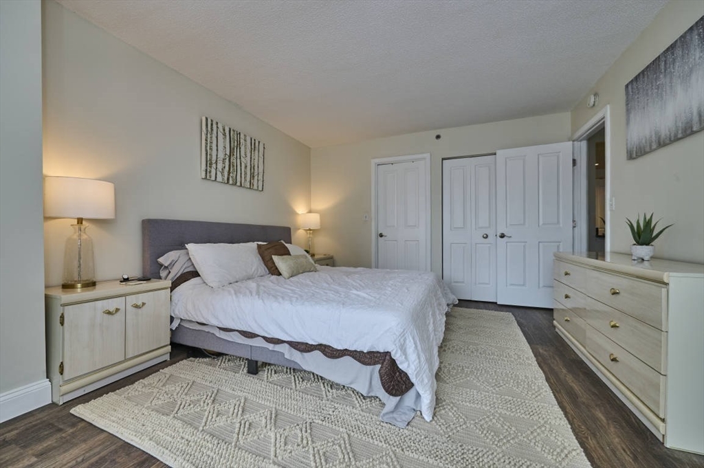 10 Museum Way, Unit 525 Cambridge, MA 02141 - Photo 10 of 22 a spacious bedroom with a bed and a lamp