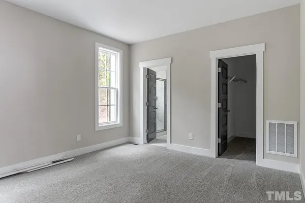 an empty room with windows and closet