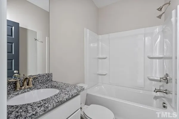 a view of an empty room with closet and a window