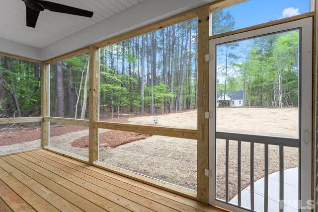 a view of a room with wooden floor and floor to ceiling windows