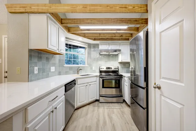 a kitchen with stainless steel appliances a sink and cabinets