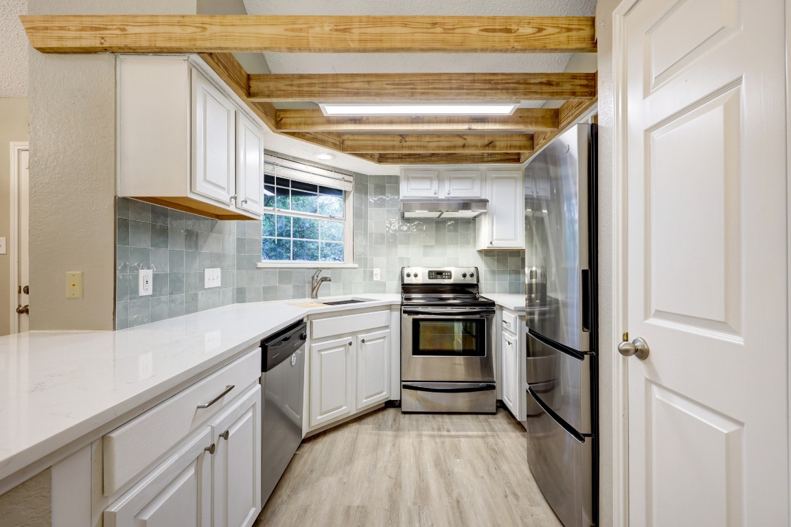 a kitchen with stainless steel appliances a sink and cabinets