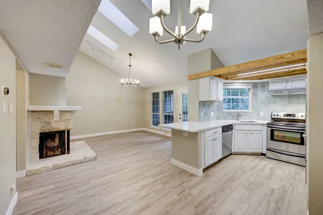 a large kitchen with cabinets wooden floor and stainless steel appliances