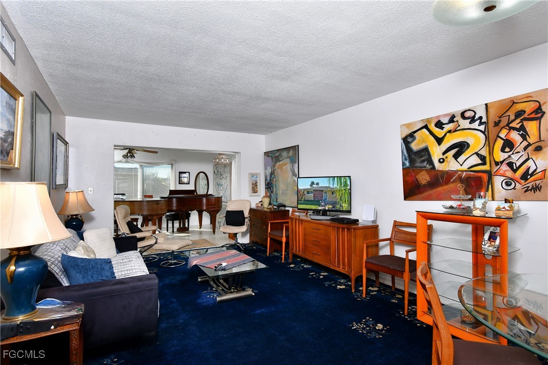 2212 East 6th Street Lehigh Acres, FL 33936 - Photo 13 of 34 a living room with furniture and a flat screen tv