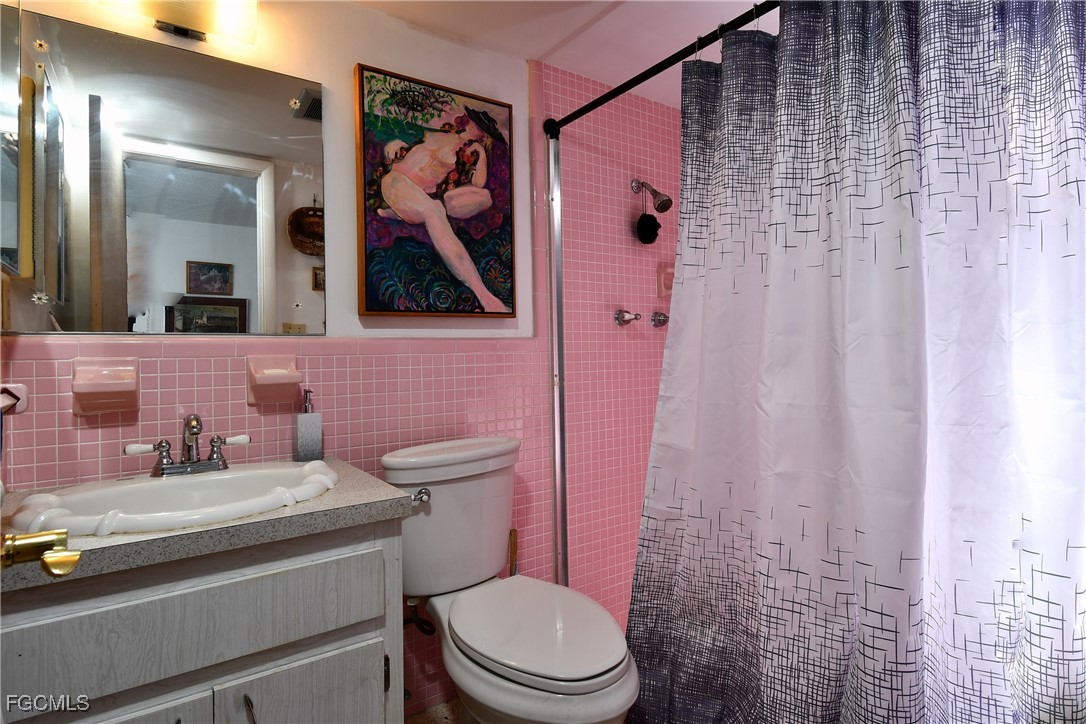 2212 East 6th Street Lehigh Acres, FL 33936 - Photo 25 of 34 a bathroom with a sink a toilet and shower curtain