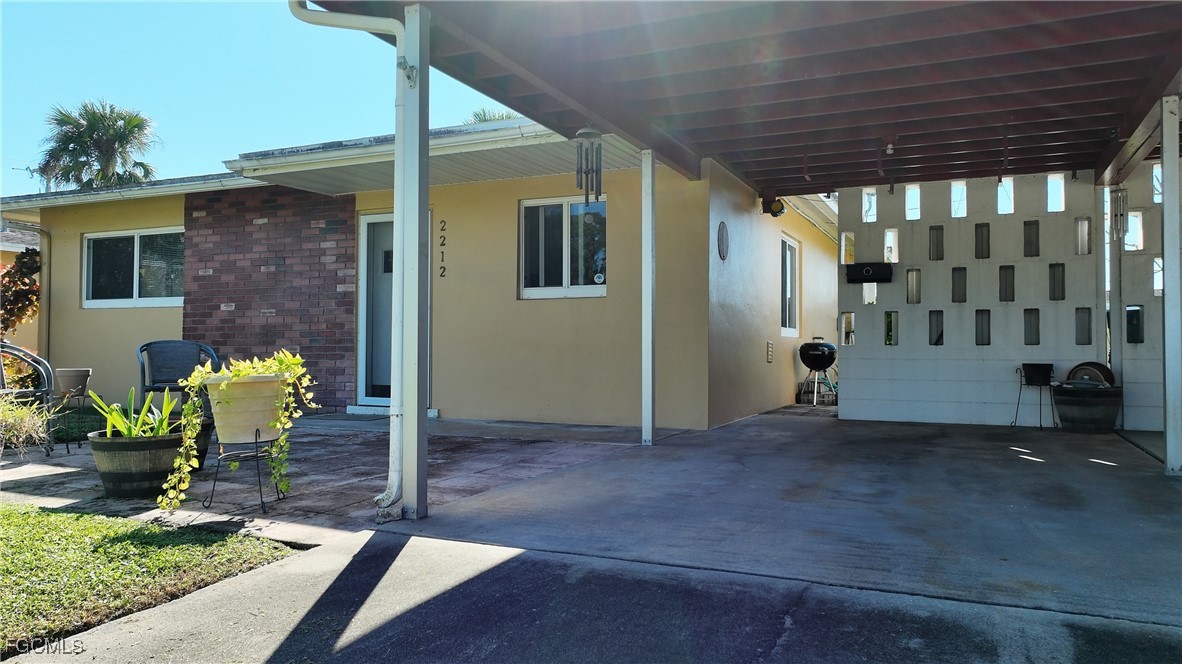 2212 East 6th Street Lehigh Acres, FL 33936 - Photo 3 of 34 a view of a porch with a table and chairs and potted plants