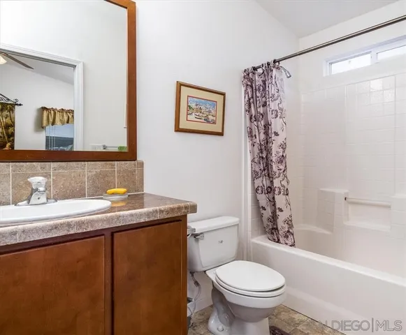 a bathroom with a granite countertop toilet sink and a mirror