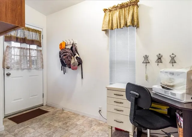 a view of a workspace with furniture and a window
