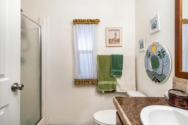 a bathroom with a granite countertop toilet sink and mirror