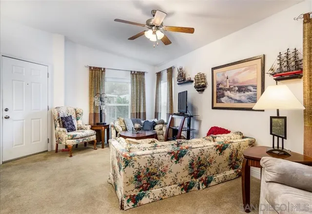 a living room with furniture chandelier and a large window