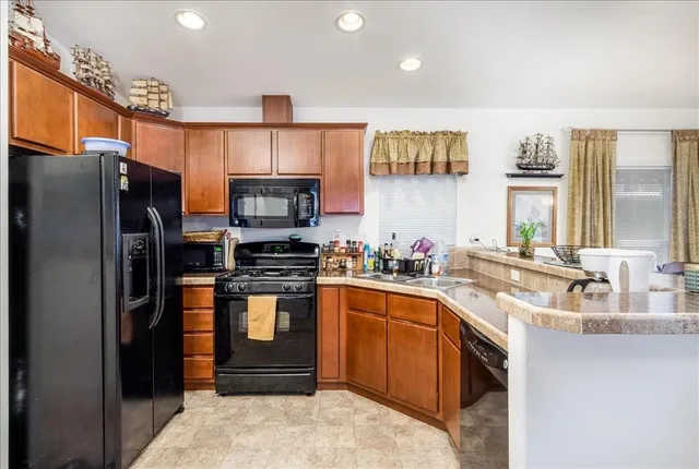 a kitchen with stainless steel appliances granite countertop a refrigerator and a sink