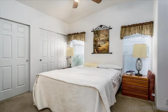 a bedroom with a bed and a lamp on dresser