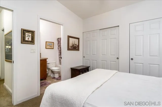 a bedroom with a bed and a painting on the wall