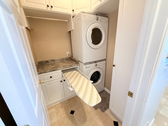 1562 Fairway Ridge Road Draper, UT 84020 - Photo 35 of 60 Dedicated laundry area featuring stacked appliances, overhead cabinetry, a countertop with a built-in ironing board, and tile flooring
