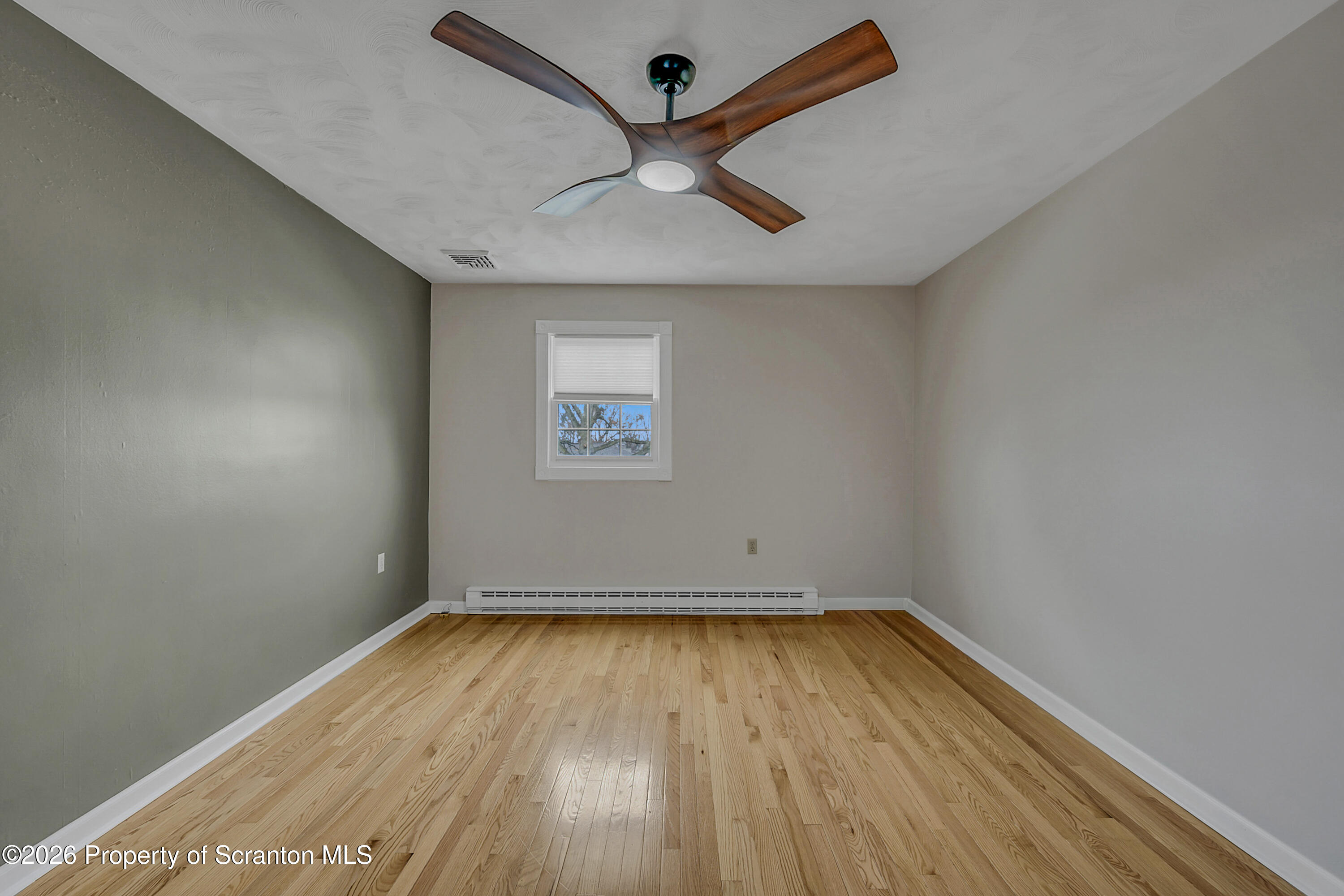 804 School Street Moosic, PA 18507 - Photo 19 of 67 an empty room with a ceiling fan and wooden floor