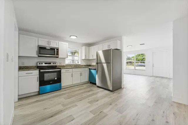 a kitchen with a refrigerator cabinets and wooden floor