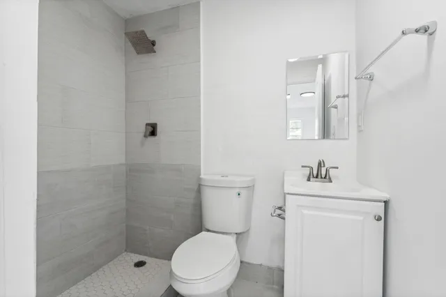 a bathroom with a sink a toilet and shower