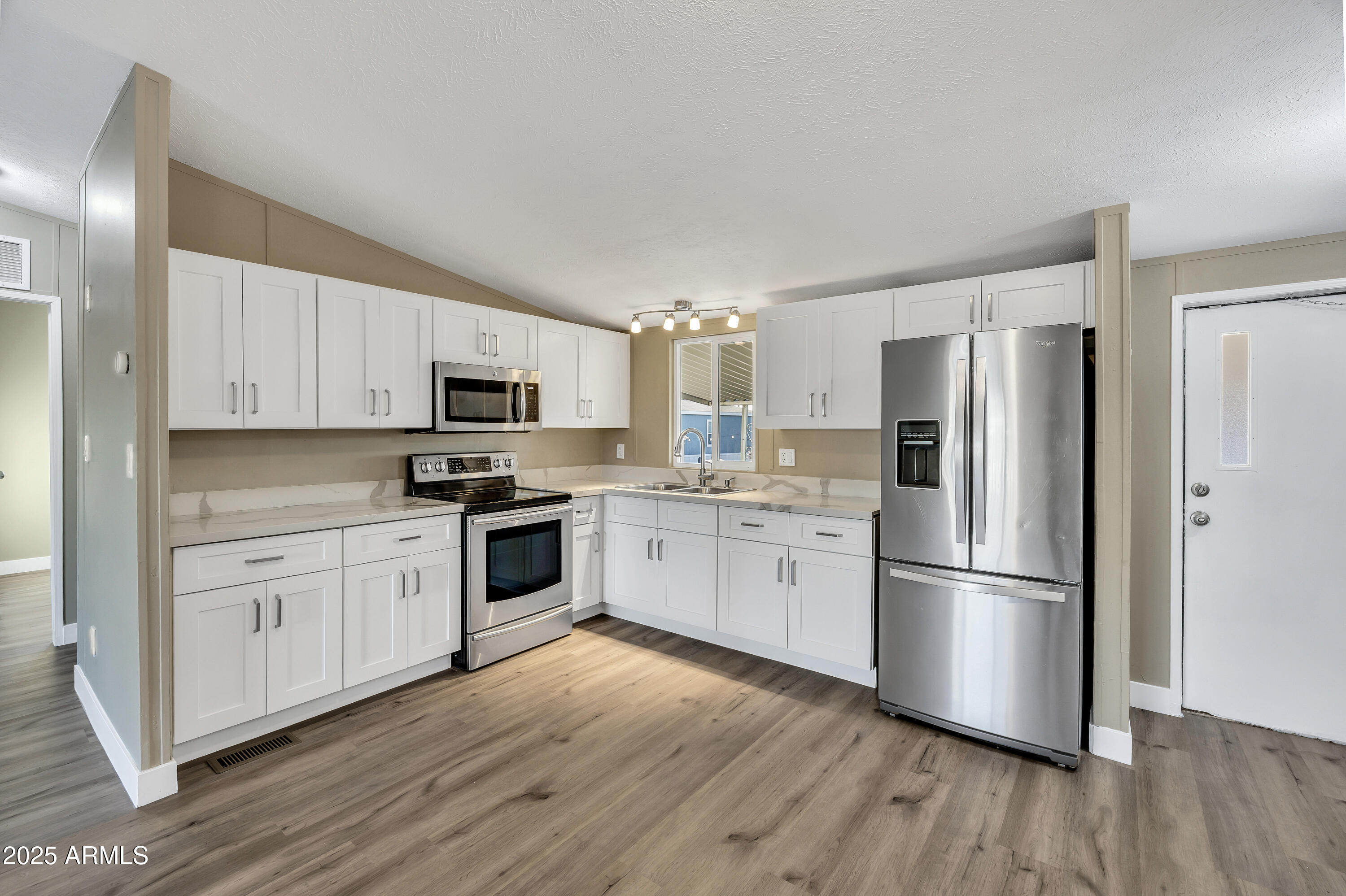 2000 South Apache Road, Unit 220 Buckeye, AZ 85326 - Photo 21 of 25 a kitchen with cabinets stainless steel appliances and wooden floor