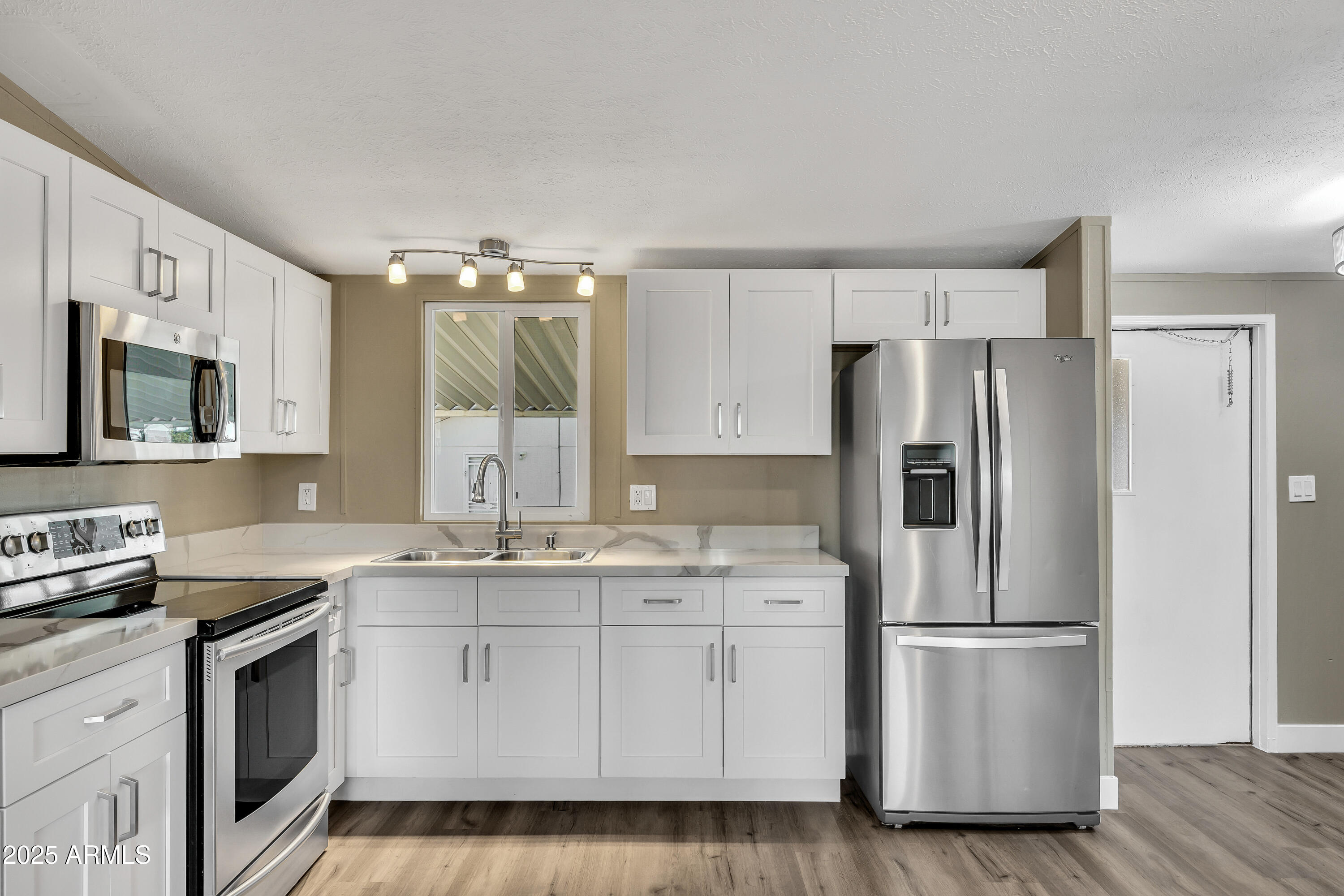 2000 South Apache Road, Unit 220 Buckeye, AZ 85326 - Photo 22 of 25 a kitchen with a white cabinets and white stainless steel appliances