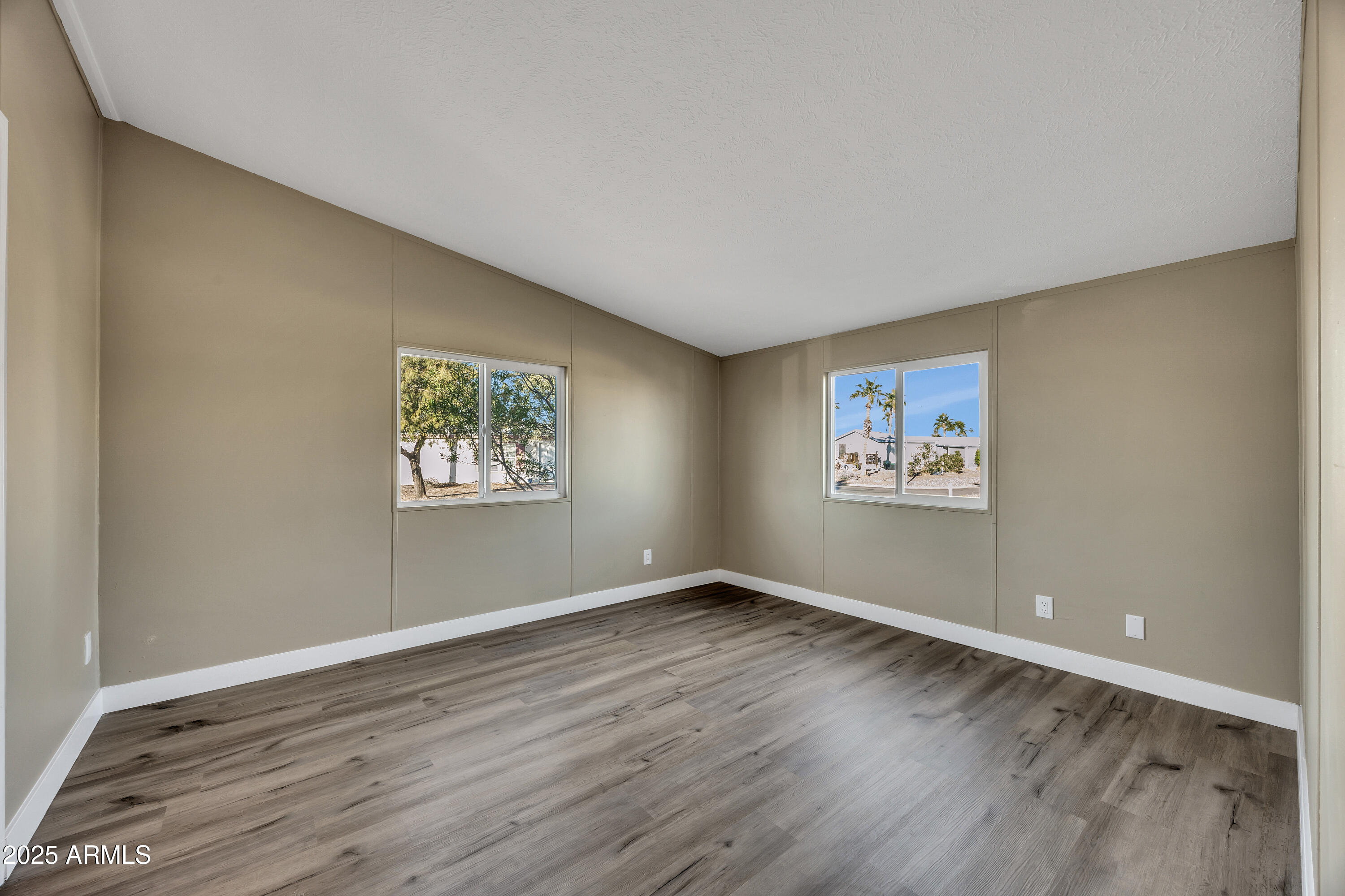 2000 South Apache Road, Unit 220 Buckeye, AZ 85326 - Photo 25 of 25 a view of an empty room with wooden floor and a window